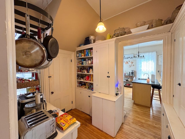 81 Parkview Ave, Bangor, ME 04401 - kitchen with light wood-type flooring, hanging light fixtures, open shelves, lofted ceiling, and white cabinets
