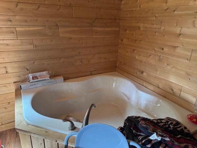 302 Haines Corner Rd, Livermore Falls, ME 04254 - bathroom with a tub and wood walls