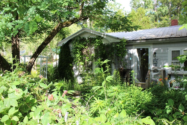 7 Maple St, Milbridge, ME 04658 - view of side of home with a metal roof and a chimney