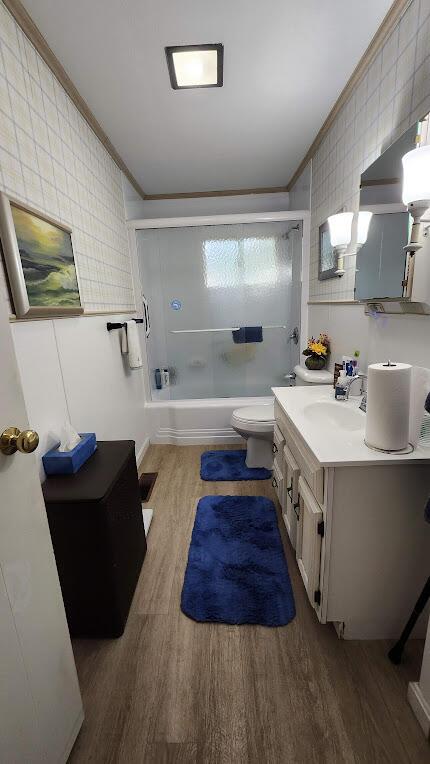 32 Highland Ave, Lincoln, ME 04457 - bathroom with crown molding, wood finished floors, vanity, and washtub / shower combination