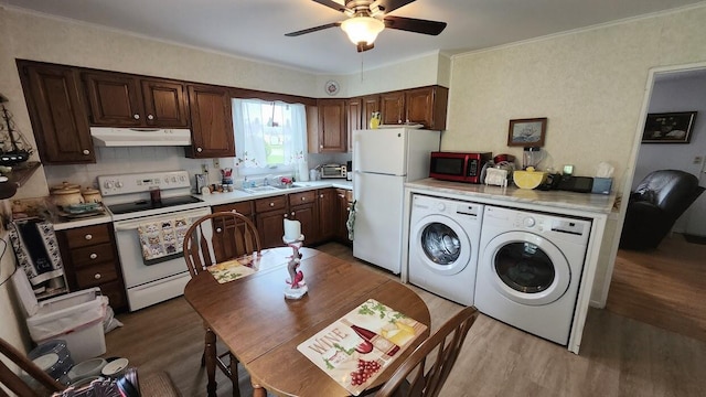 32 Highland Ave, Lincoln, ME 04457 - kitchen with white appliances, separate washer and dryer, under cabinet range hood, wood finished floors, and ornamental molding