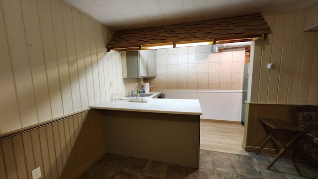 32 Highland Ave, Lincoln, ME 04457 - kitchen with a peninsula, light countertops, wood walls, and white cabinetry