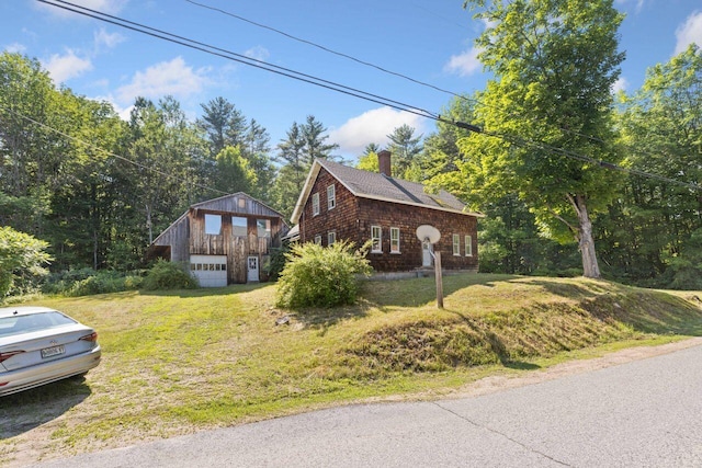 48 Elm St, Newfield, ME 04095 - view of home's exterior with a detached garage, a lawn, a chimney, and roof with shingles