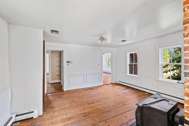 48 Elm St, Newfield, ME 04095 - unfurnished living room with healthy amount of natural light, hardwood / wood-style flooring, and a baseboard radiator