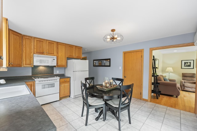 38 Tarr Ave, Lewiston, ME 04240 - kitchen with white appliances, dark countertops, light tile patterned flooring, and a chandelier