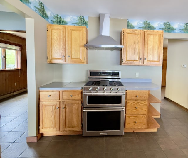 270 Grant Rd, Sullivan, ME 04664 - kitchen with wall chimney range hood, double oven range, dark tile patterned floors, light brown cabinets, and light countertops