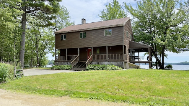 270 Grant Rd, Sullivan, ME 04664 - view of front facade featuring covered porch, a chimney, and a front lawn
