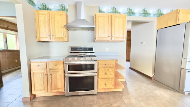 270 Grant Rd, Sullivan, ME 04664 - kitchen with appliances with stainless steel finishes, wall chimney exhaust hood, light brown cabinets, light countertops, and a baseboard radiator