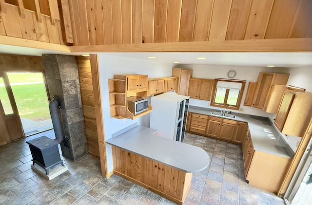 270 Grant Rd, Sullivan, ME 04664 - kitchen with stainless steel microwave, a wood stove, stone tile flooring, open shelves, and light countertops