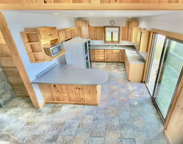 270 Grant Rd, Sullivan, ME 04664 - kitchen with stainless steel microwave, stone tile floors, light brown cabinets, light countertops, and open shelves