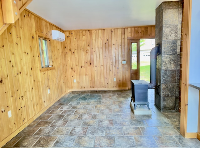 270 Grant Rd, Sullivan, ME 04664 - unfurnished room with stone finish flooring, wooden walls, and a wood stove