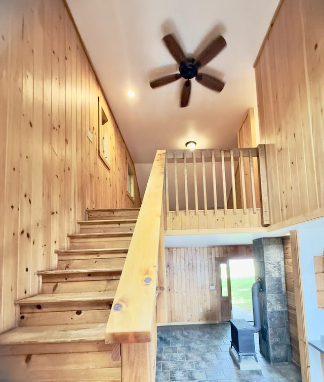 270 Grant Rd, Sullivan, ME 04664 - stairs with a wood stove, a ceiling fan, wooden walls, and stone finish flooring