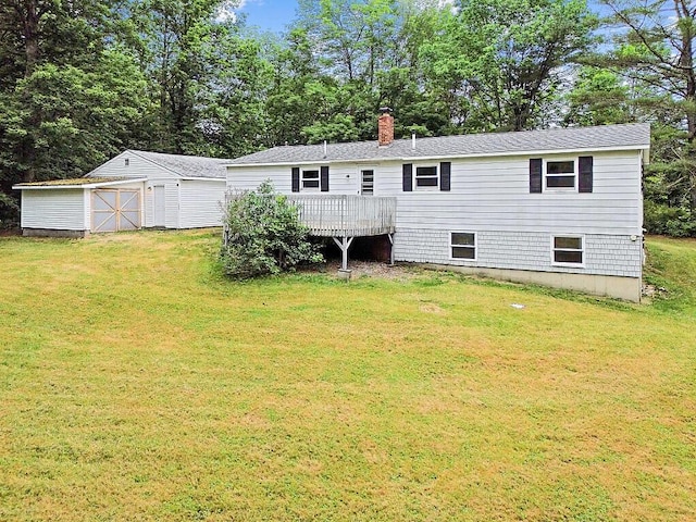 329 Reed Rd, Windsor, ME 04363 - rear view of house featuring a lawn, a wooden deck, an outbuilding, a chimney, and view of scattered trees