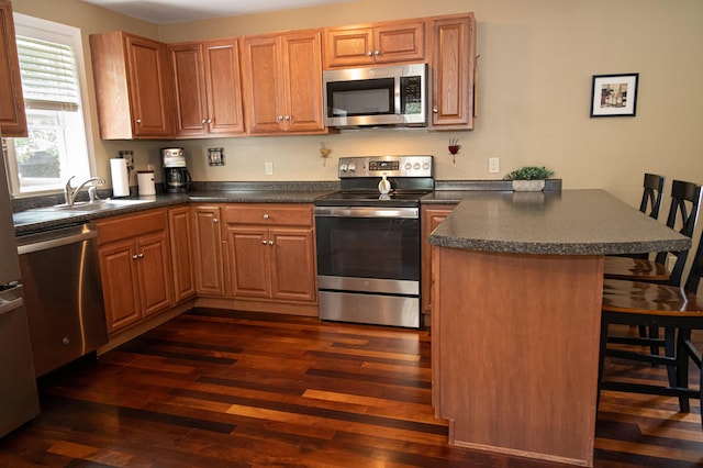 13 Bremen St, Westbrook, ME 04092 - kitchen featuring a peninsula, appliances with stainless steel finishes, dark wood finished floors, and dark countertops