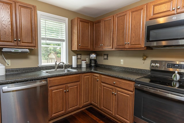 13 Bremen St, Westbrook, ME 04092 - kitchen with appliances with stainless steel finishes, dark countertops, brown cabinetry, and dark wood finished floors