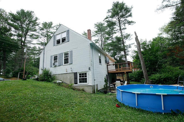 17 Duncan Rd, Augusta, ME 04330 - back of property with a wooden deck, a chimney, a yard, an outdoor pool, and view of wooded area