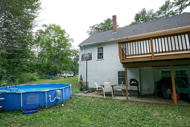 17 Duncan Rd, Augusta, ME 04330 - back of house with a chimney, a lawn, an outdoor pool, roof with shingles, and a wooden deck
