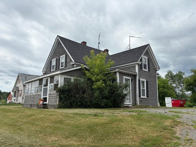 41 S Main St, Burnham, ME 04922 - view of front of house featuring roof with shingles, a chimney, and a front lawn