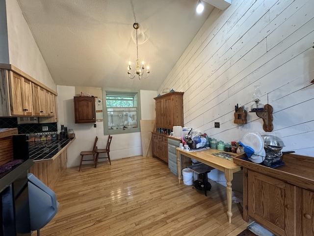 1698 Exeter Rd, Exeter, ME 04435 - kitchen featuring lofted ceiling, light wood-style floors, a chandelier, backsplash, and wood walls