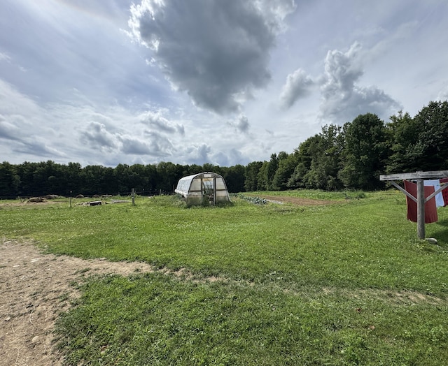 1698 Exeter Rd, Exeter, ME 04435 - view of green lawn featuring an exterior structure, an outbuilding, a rural view, and a forest view