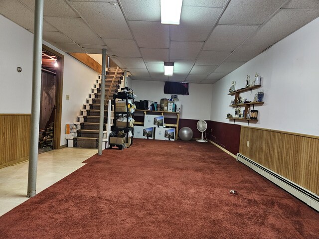 381 Birch St, Bangor, ME 04401 - finished basement with wood walls, carpet floors, stairway, baseboard heating, and a wainscoted wall