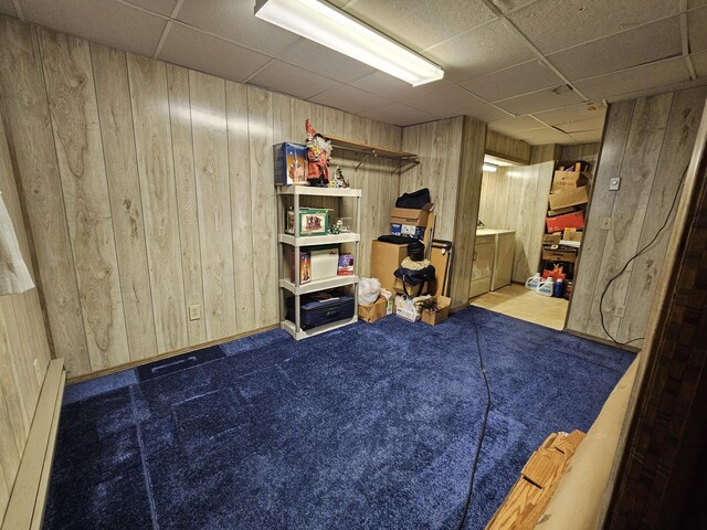 381 Birch St, Bangor, ME 04401 - finished below grade area with wood walls, a drop ceiling, carpet flooring, and a baseboard heating unit
