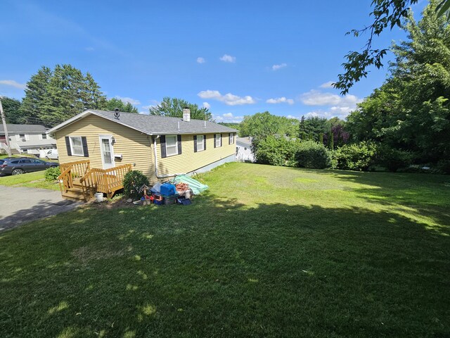 381 Birch St, Bangor, ME 04401 - view of side of home with a lawn, a chimney, a deck, and a shingled roof