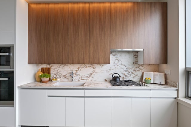 166 Fore St Unit 25, Portland, ME 04101 - kitchen featuring black oven, stainless steel gas stovetop, modern cabinets, and tasteful backsplash