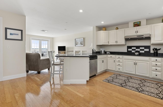 1 E Grand Ave Unit 503, Old Orchard Beach, ME 04064 - kitchen with stainless steel dishwasher, under cabinet range hood, open floor plan, dark countertops, and a peninsula