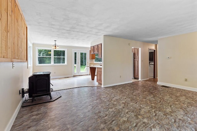 2672 N Belfast Ave, Augusta, ME 04330 - unfurnished living room featuring a wood stove and baseboards