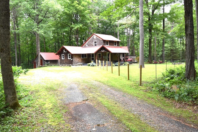108 Maple Rd, Atkinson, ME 04426 - chalet / cabin with covered porch, gravel driveway, a view of trees, and a metal roof