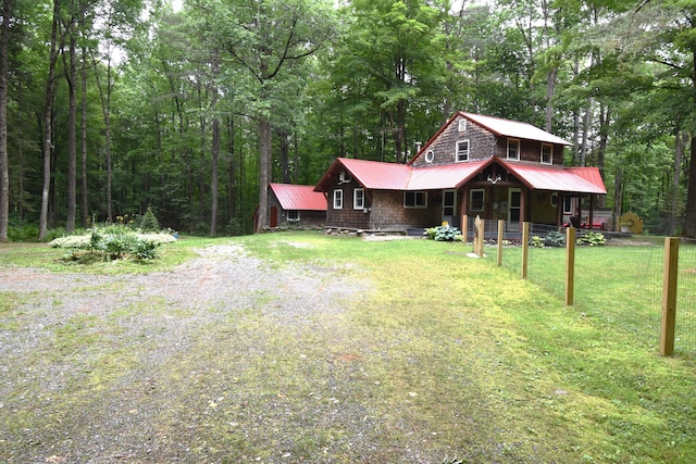108 Maple Rd, Atkinson, ME 04426 - view of front of house with a front yard, a porch, a metal roof, and a wooded view