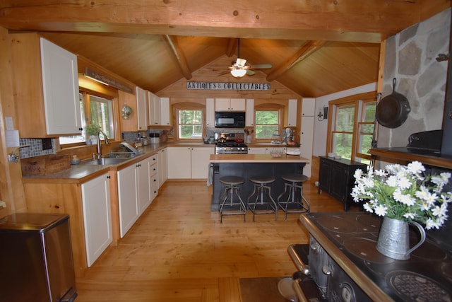 108 Maple Rd, Atkinson, ME 04426 - kitchen featuring black microwave, light wood-style floors, white cabinetry, ceiling fan, and gas stove