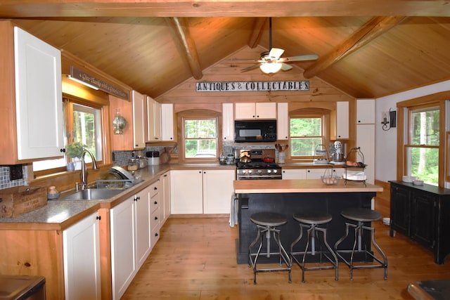 108 Maple Rd, Atkinson, ME 04426 - kitchen featuring black microwave, stainless steel gas range, light wood-type flooring, white cabinets, and wood ceiling