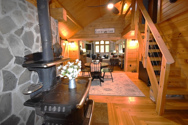 108 Maple Rd, Atkinson, ME 04426 - living area with stairway, vaulted ceiling, wooden walls, a wood stove, and wooden ceiling
