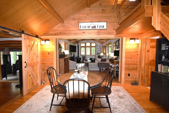 108 Maple Rd, Atkinson, ME 04426 - dining room with a barn door, wood walls, wooden ceiling, and light wood-style floors