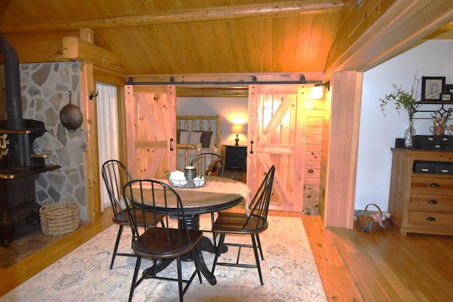 108 Maple Rd, Atkinson, ME 04426 - dining space with a barn door, wood ceiling, wood finished floors, and a wood stove