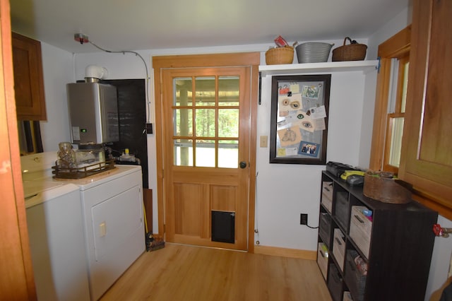 108 Maple Rd, Atkinson, ME 04426 - entryway featuring washing machine and dryer, tankless water heater, and light wood finished floors