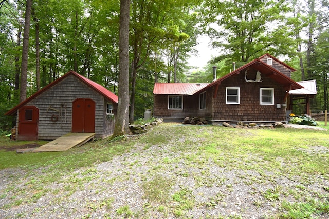 108 Maple Rd, Atkinson, ME 04426 - rear view of property with a metal roof, an outbuilding, and a lawn
