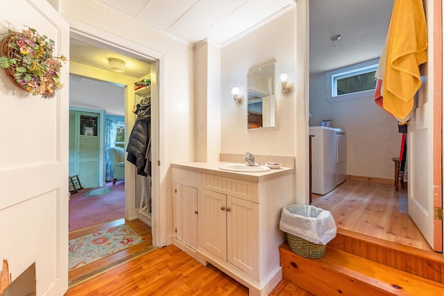 131 River Rd, Newcastle, ME 04553 - bathroom featuring washing machine and dryer, wood finished floors, vanity, ornamental molding, and plenty of natural light