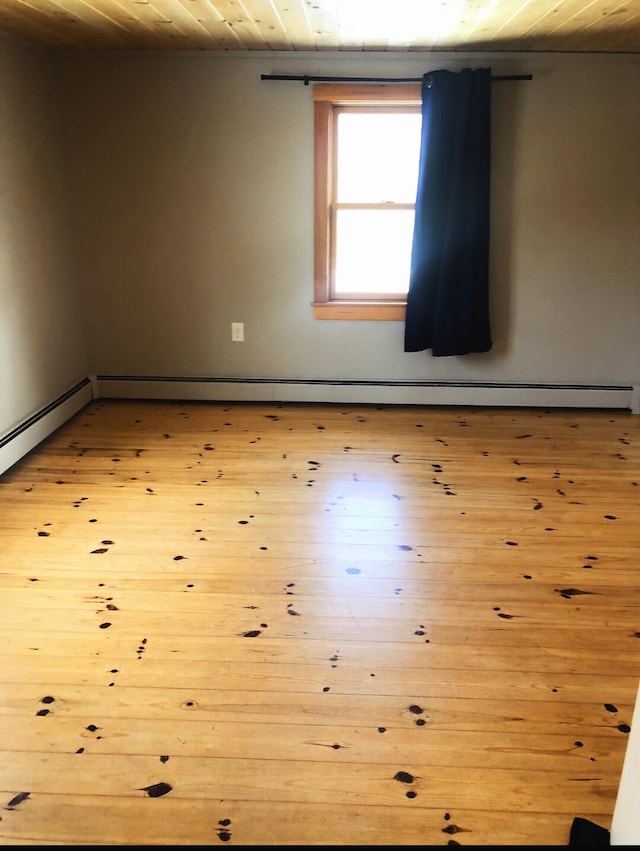 120 Sunday River Rd, Bethel, ME 04217 - empty room with wood ceiling, light wood-style floors, and a baseboard heating unit
