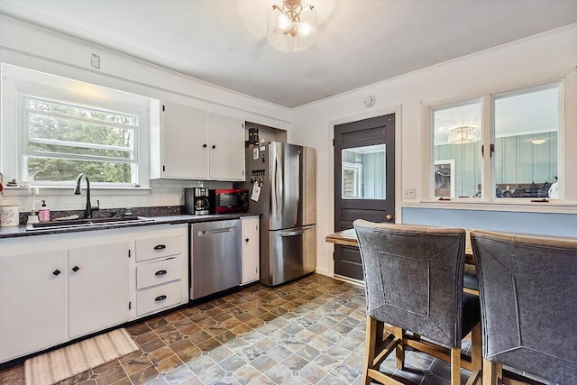 77 W River Rd, Waterville, ME 04901 - kitchen featuring appliances with stainless steel finishes, dark countertops, stone finish floors, white cabinetry, and backsplash