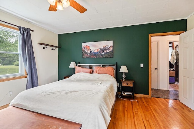 77 W River Rd, Waterville, ME 04901 - bedroom with an accent wall, wood-type flooring, ornamental molding, and a ceiling fan