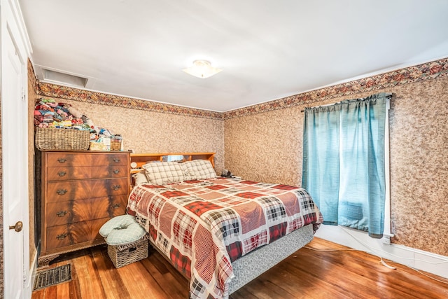 131 Pleasant St, Dexter, ME 04930 - bedroom featuring wood finished floors, wallpapered walls, and attic access