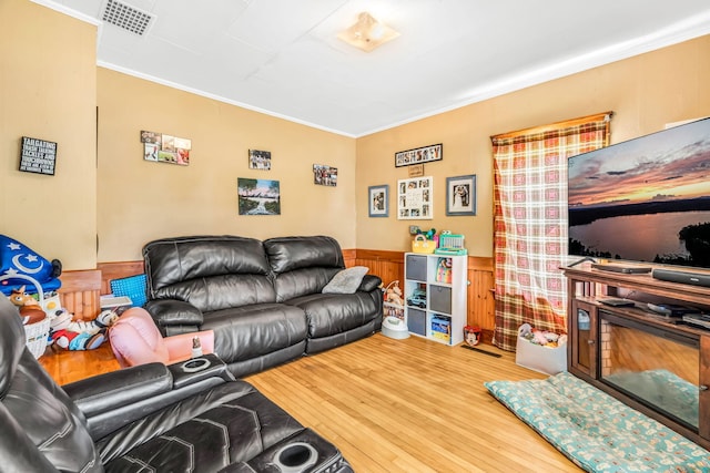 131 Pleasant St, Dexter, ME 04930 - living room with crown molding, wood finished floors, and a wainscoted wall
