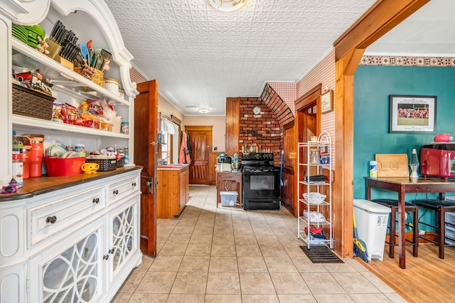 131 Pleasant St, Dexter, ME 04930 - kitchen featuring black range with electric stovetop, dark countertops, light tile patterned floors, and open shelves