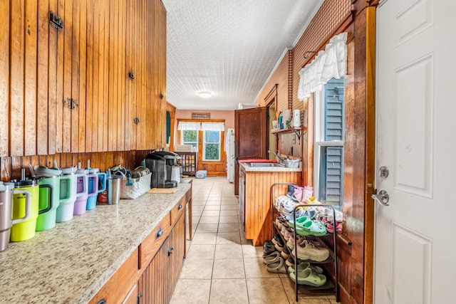 131 Pleasant St, Dexter, ME 04930 - kitchen featuring light tile patterned floors and wood walls