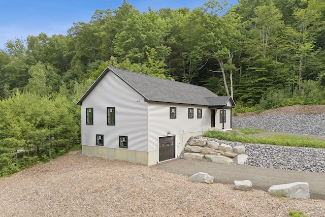 127 Bond Brook Rd, Augusta, ME 04330 - view of side of property with driveway, a shingled roof, a garage, and a forest view