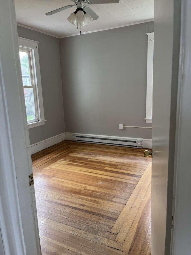 107 May St, Biddeford, ME 04005 - spare room with baseboard heating, ornamental molding, a ceiling fan, and wood-type flooring