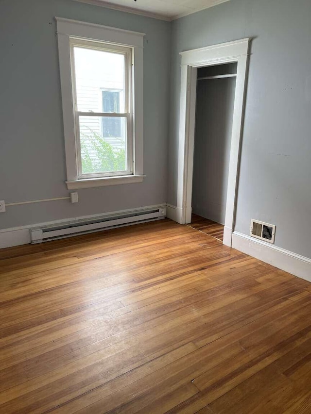 107 May St, Biddeford, ME 04005 - unfurnished bedroom featuring a baseboard heating unit and wood finished floors
